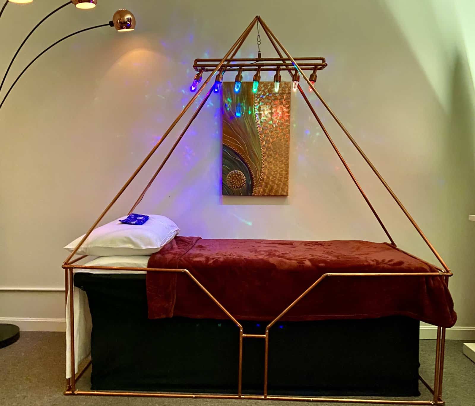 Large copper meditation pyramid used for energy alignment and healing at Pyramid Wellness